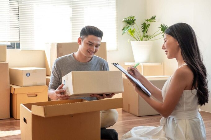 Young Asian married couple helping packing and checking together